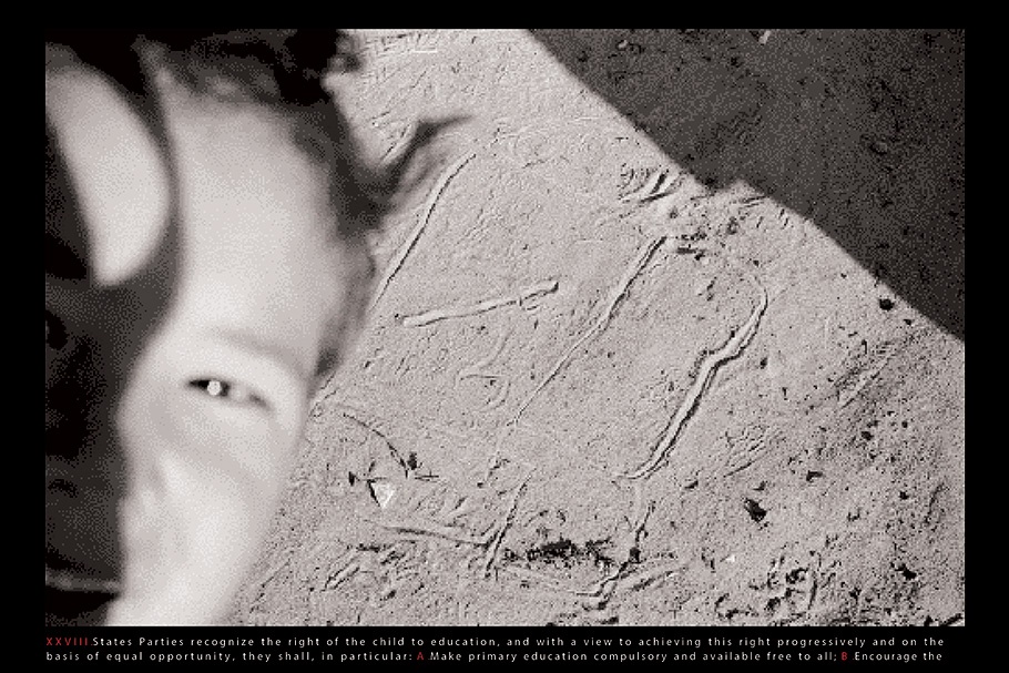 Close up of a boy’s face against a textured wall.