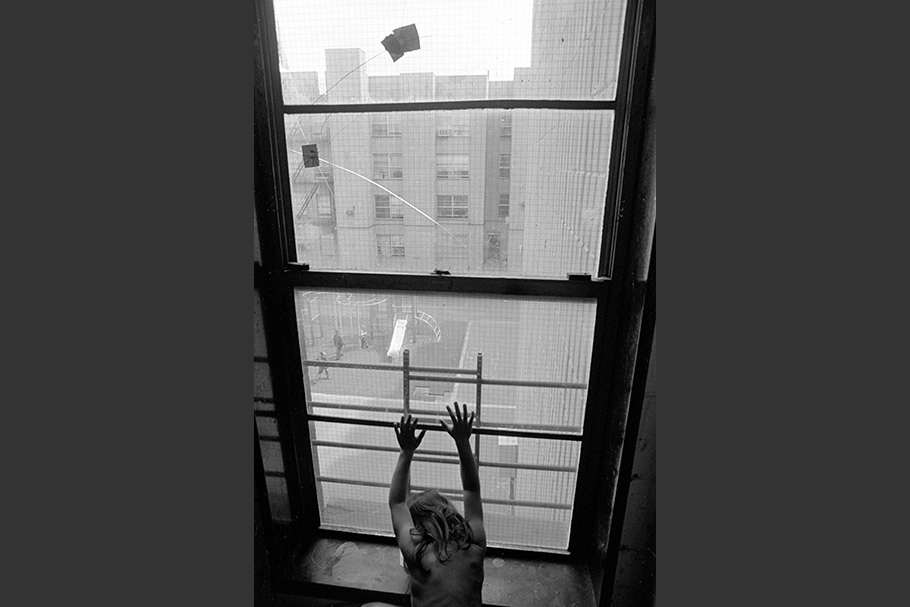 A girl with her hands against a window.