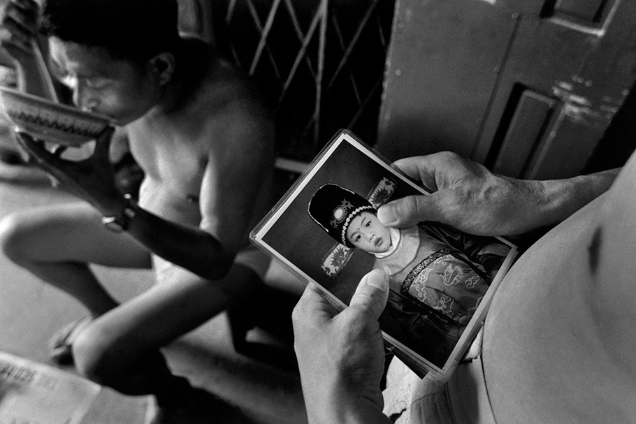 A man looks at a photograph of his son.