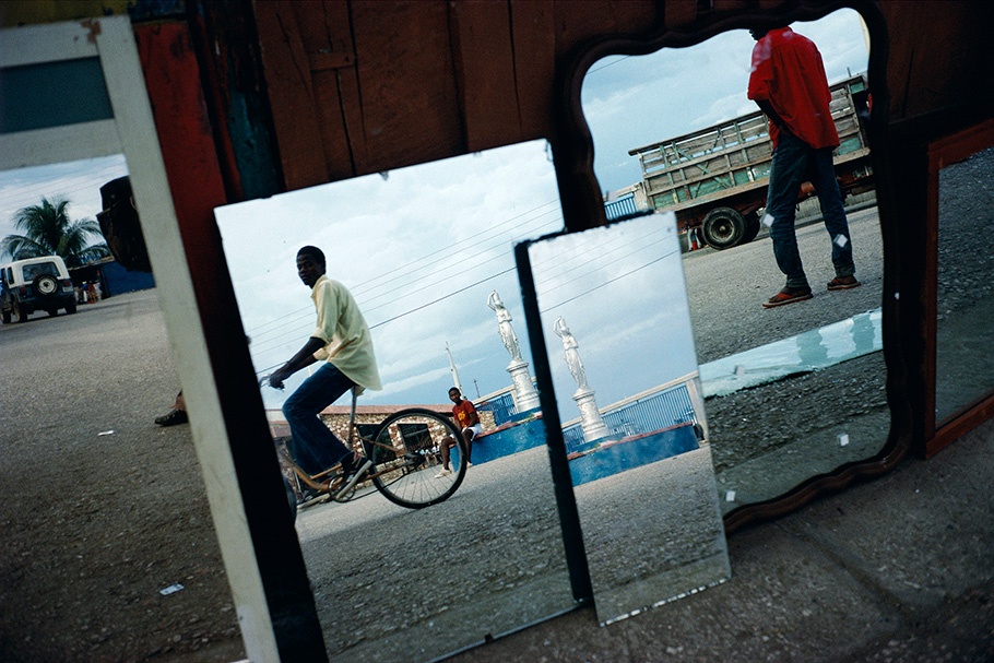 A street scene with a bicyclist reflected in mirrors.