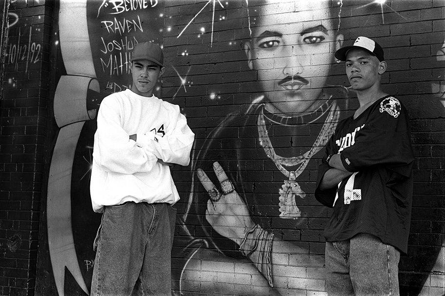 Two teenage boys in front of a mural.