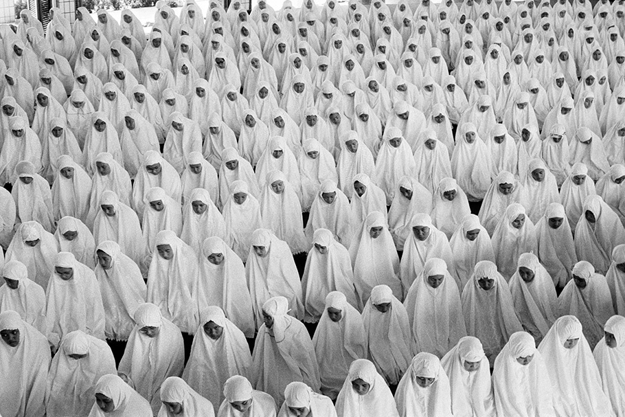 Many women praying in white headscarves.