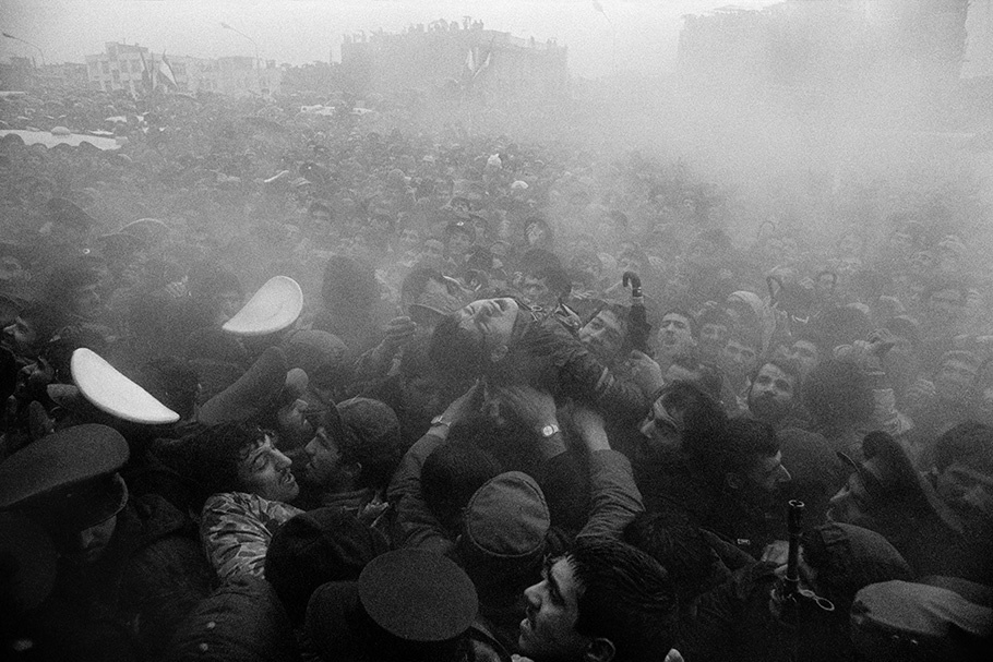A man is passed over a crowd in a haze.