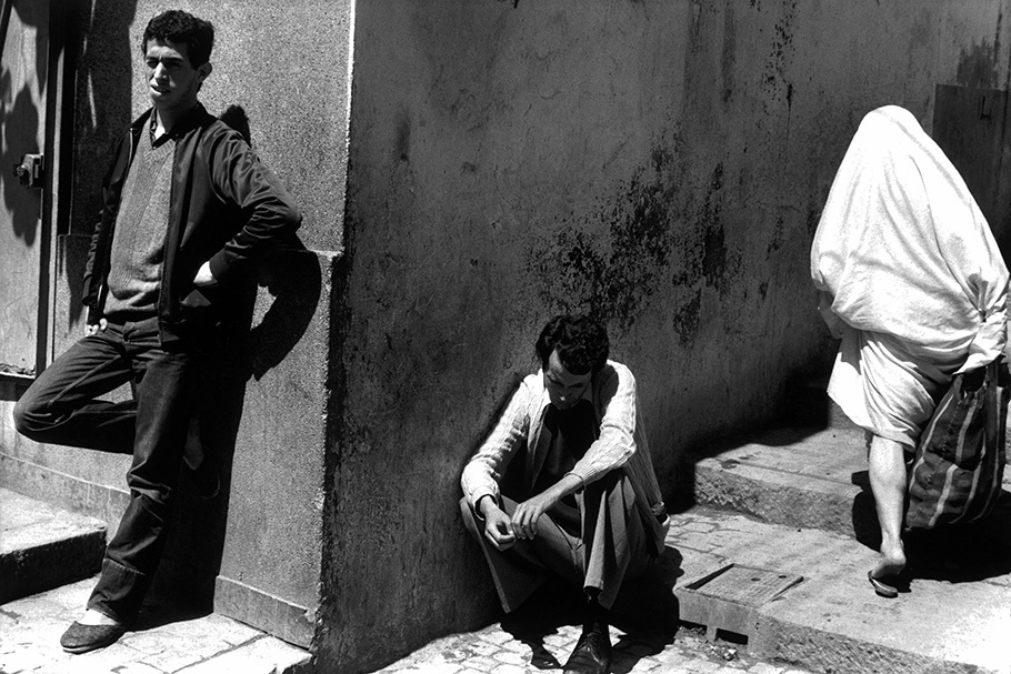 Three men outside the corner of a building.