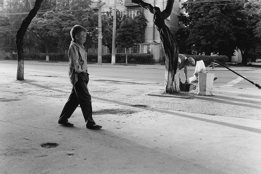 A boy walking down a street. 