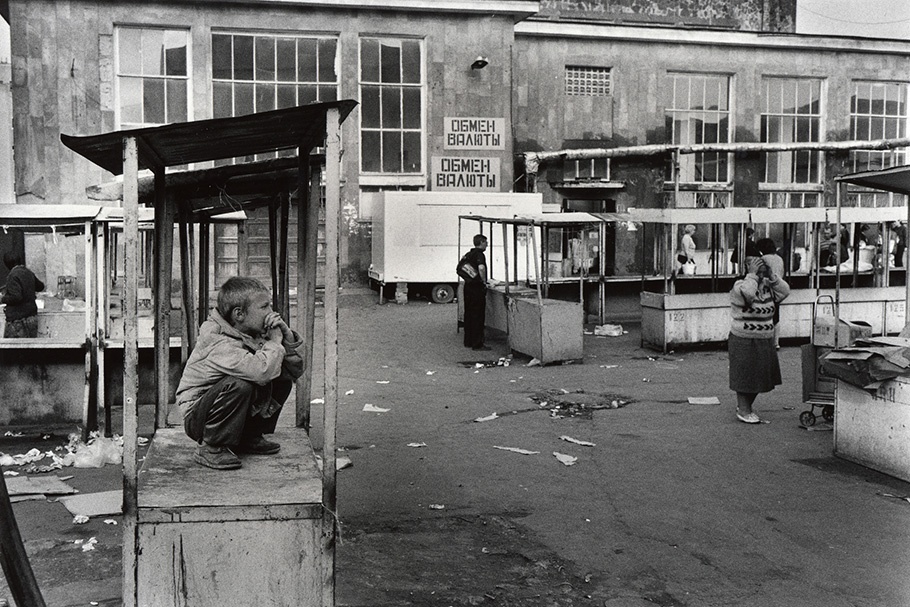 A boy with empty market stalls.