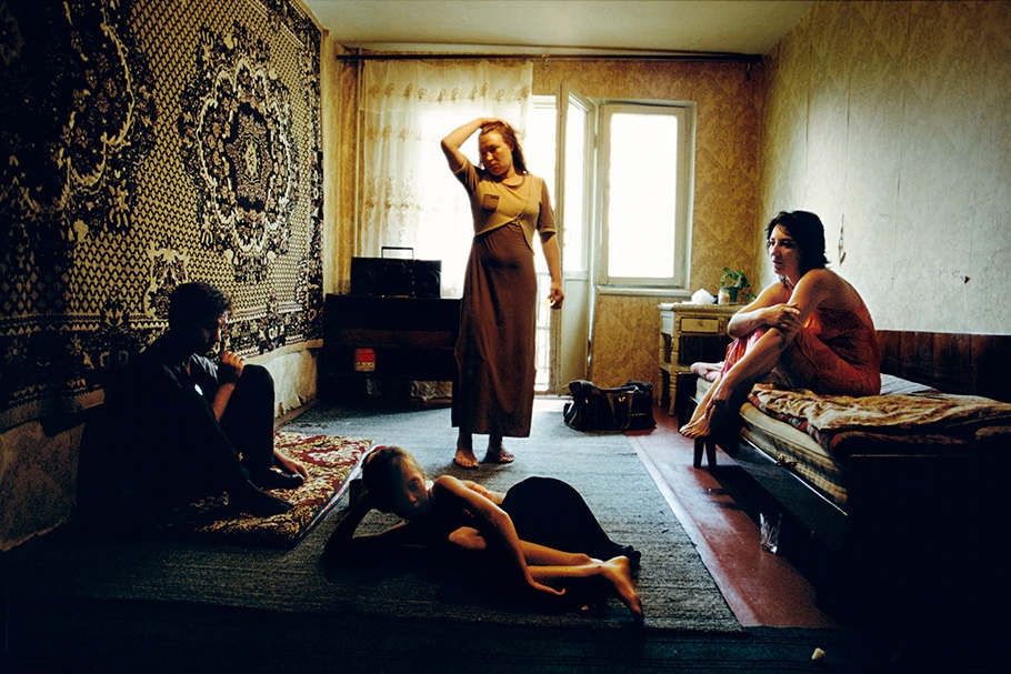Four people in a room with fabric on the walls.
