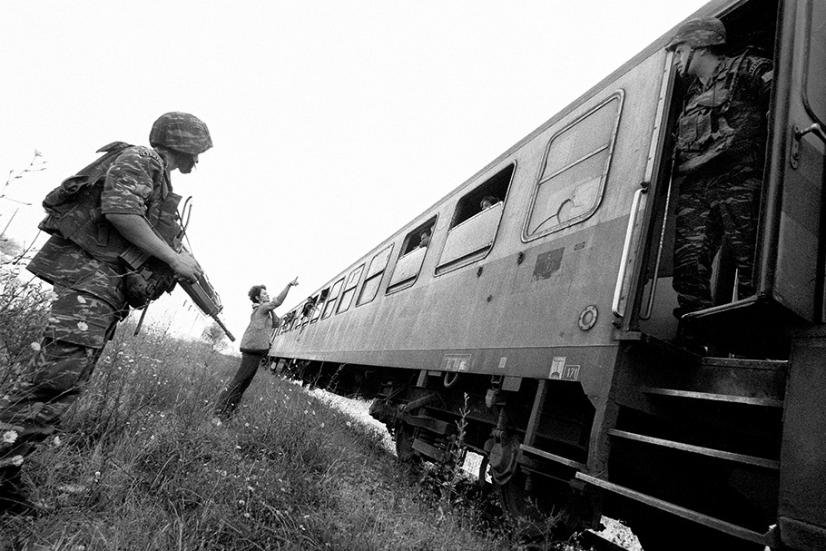 An armed soldier stands outside a train