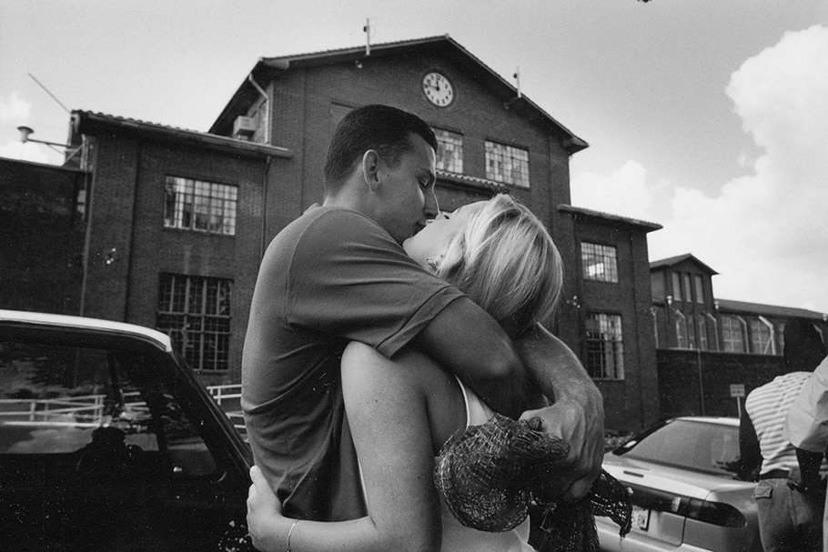 A couple kissing outside a prison.