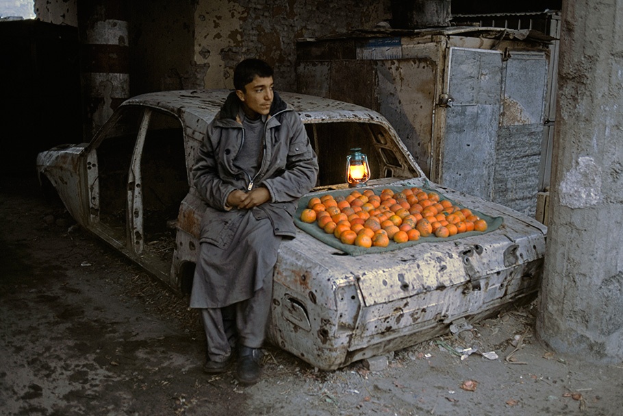 A vendor selling oranges from a car.
