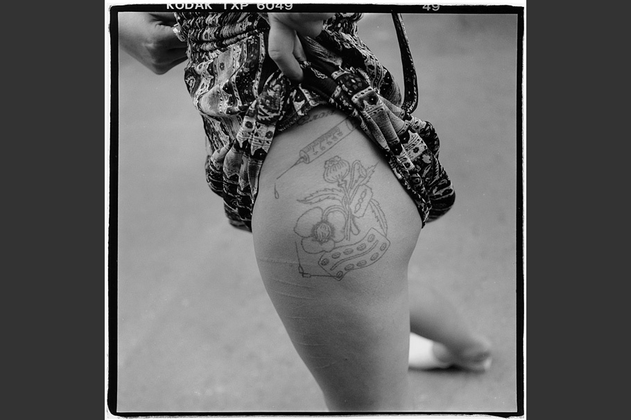 A woman showing her tattooed thigh.