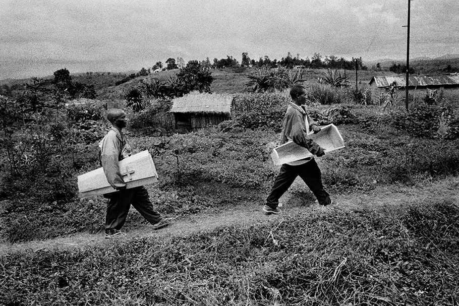 Two men carrying a child’s coffin.