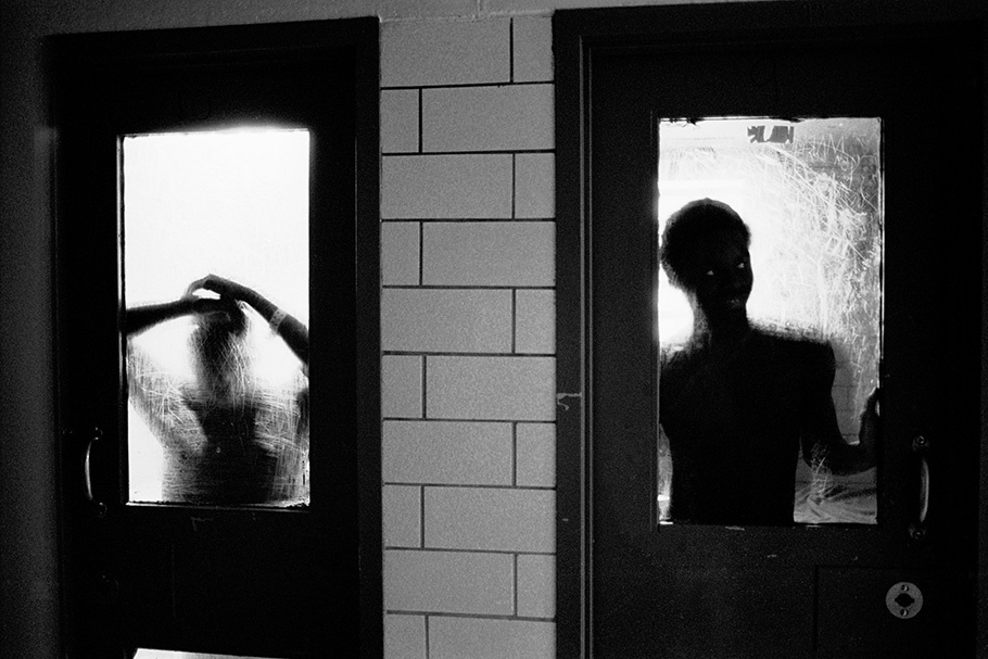 Two silhouetted figures seen through doors.