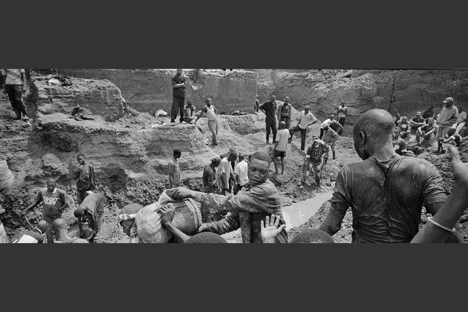 Workers carrying a sack out of a mine.