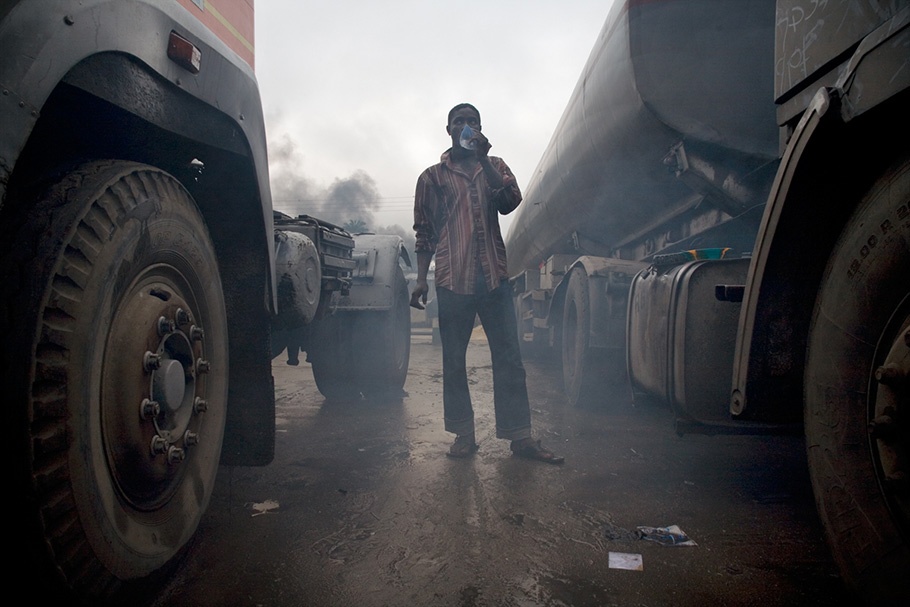 Man between trucks with smog.