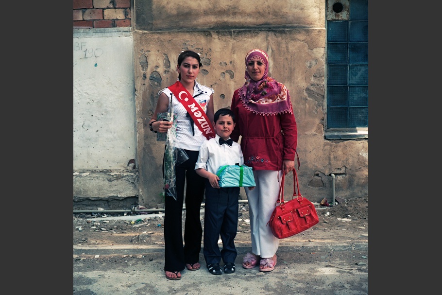 Girl with rose stands next to boy and mother.