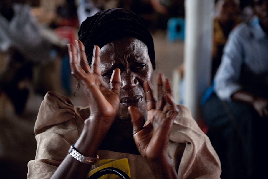 A woman cries with her hands raised in front of her face.
