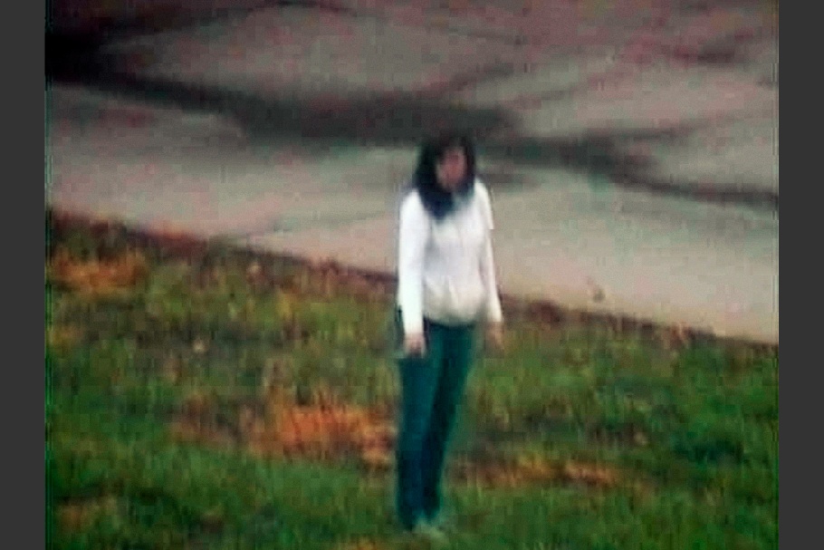 Woman wearing jeans and white shirt standing in grass