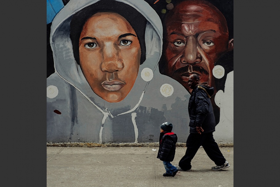 A man and a boy walking in front a mural.