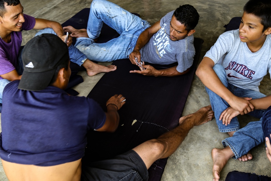 Men sitting on mats, playing cards