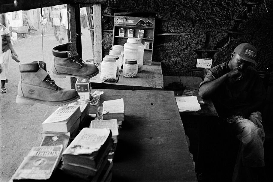 Nubian man sitting behind a counter with items for sale