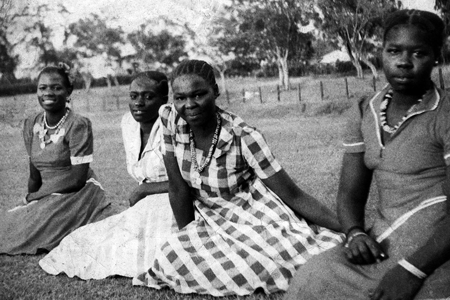 Women sitting on grass.