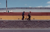 Two men walking along the border.